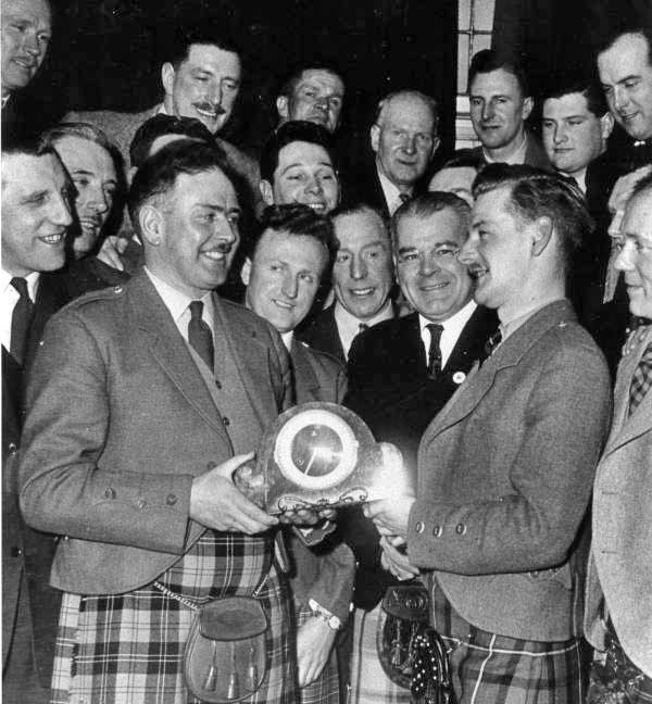 Ramsay accepts a retirement gift from incoming Edinburgh Police Pipe Major John D. Burgess in 1957.